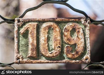 Old retro weathered painted cast iron plate with number 109