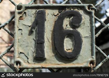 Old retro weathered painted cast iron plate with number 16
