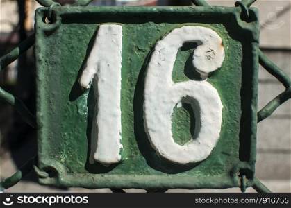 Old retro weathered painted cast iron plate with number 16