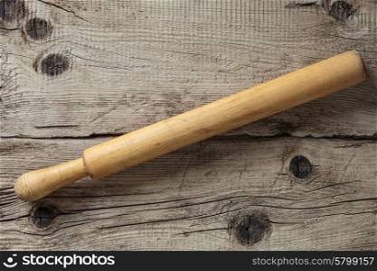 Old rolling pin on a wooden vintage board