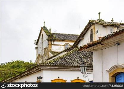 Old roofs and churches in the historic city of Paraty on the green coast of Rio de Janeiro on a cloudy day. Old roofs and churches in the historic city of Paraty