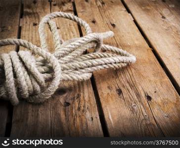 Old rope twisted and tied in a bundle on a rough wooden background