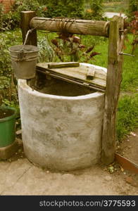 old rotten water well in sumer garden, rural scenery