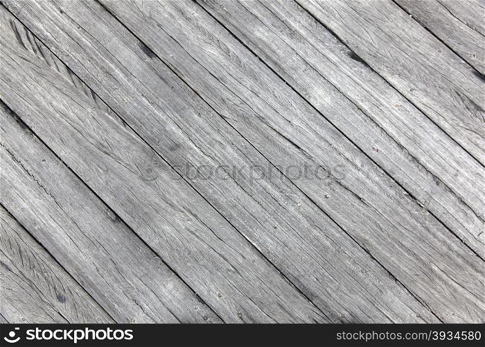 old rough wheathered battered textured grey wooden planks with cracks diagonally placed