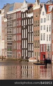 Old row houses by the canal in the city of Amsterdam, Holland, Netherlands.
