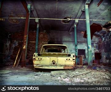 old ruined garage interior with old car