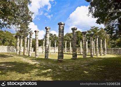 Old ruins of columns in a grassy field, The Market, Chichen Itza, Yucatan, Mexico