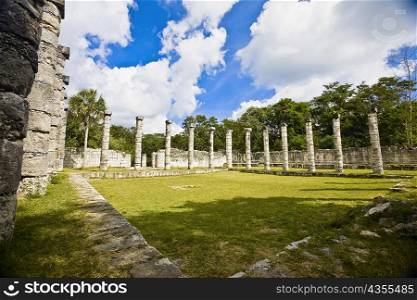 Old ruins of columns in a grassy field, The Market, Chichen Itza, Yucatan, Mexico