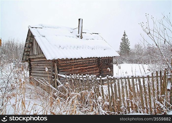 old rural wooden house amongst snow