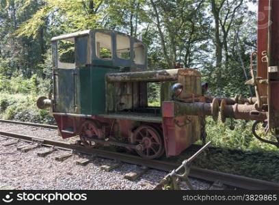 old rusted small green locomotive from train at trainstation hombourg in belgium