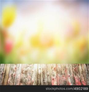 old rustic Wooden table over blurred flowers garden background