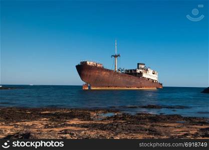 Old rusty boat stranded on the shore in Lanzarote, Canary Islands, Spain