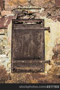 Old rusty door on a stone wall