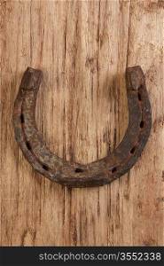 old rusty horseshoe on a wood background