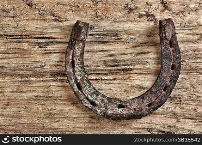 old rusty horseshoe on a wood background
