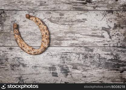 Old rusty horseshoe on vintage wooden board
