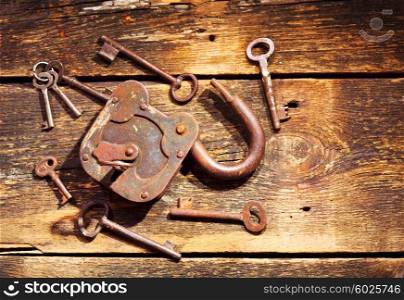 old rusty lock and keys on wooden table