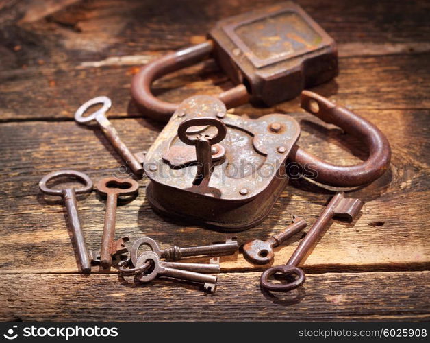 old rusty lock and keys on wooden table