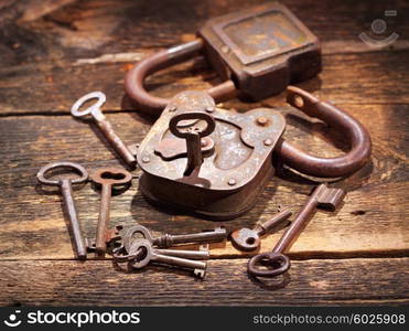 old rusty lock and keys on wooden table