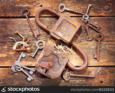 old rusty locks and keys on wooden table