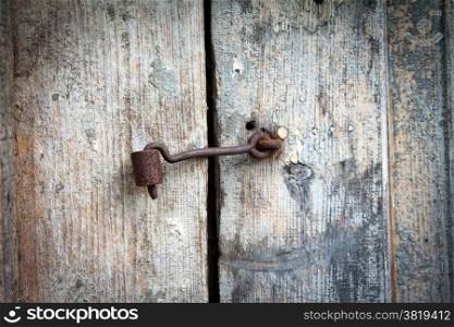 old rusty metal hook on the old door