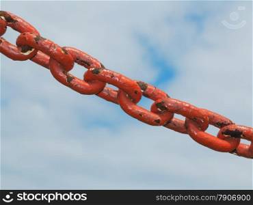 Old rusty metal steel red chain links segment. Sky cloudy background.