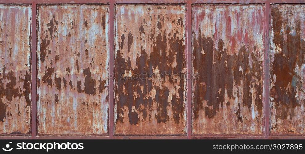 Old rusty metal wall with cracked red paint, texture background