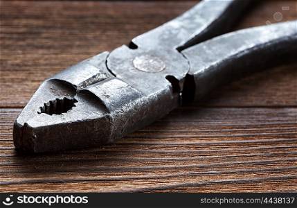 old rusty pliers on wooden background