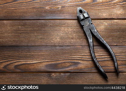 old rusty pliers on wooden background