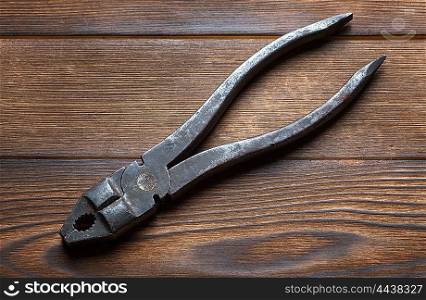 old rusty pliers on wooden background