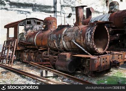 old rusty steam locomotive in background of the wall