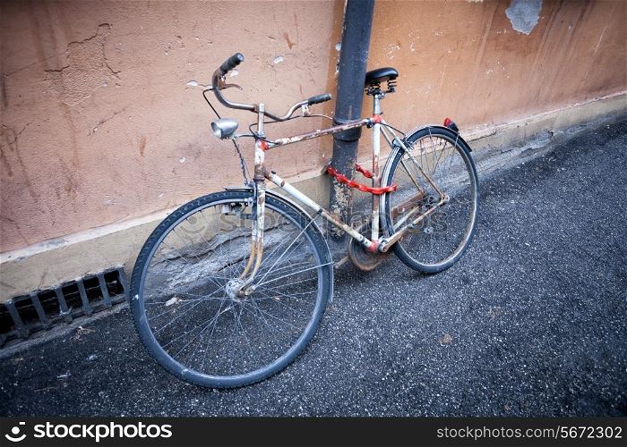 old rusty vintage bicycle near the concrete wall