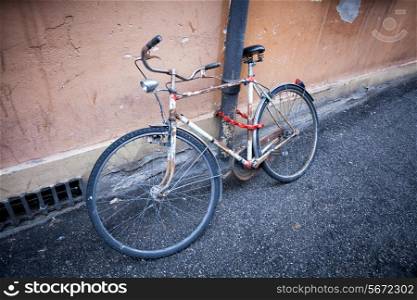 old rusty vintage bicycle near the concrete wall