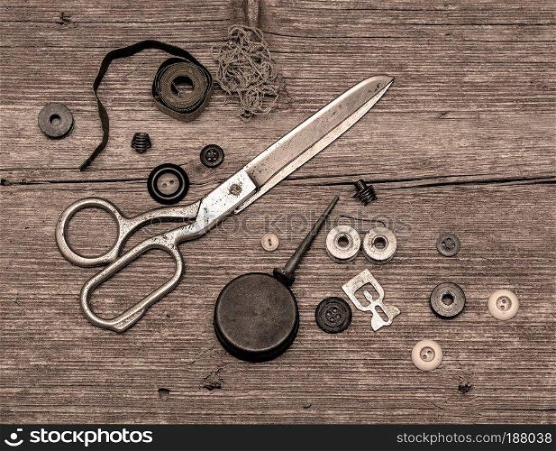 Old scissors and buttons on the wooden table