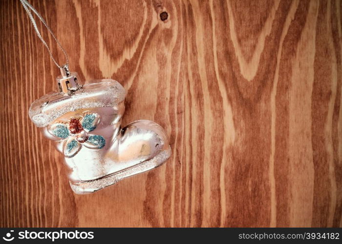 Old shoe shaped christmas bauble hanging on wooden background