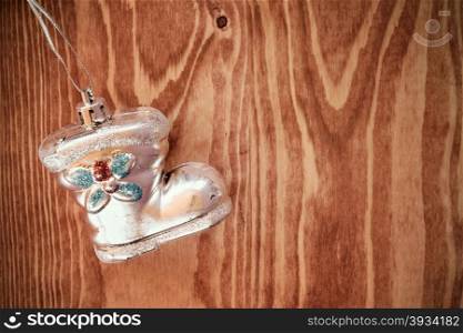 Old shoe shaped christmas bauble hanging on wooden background