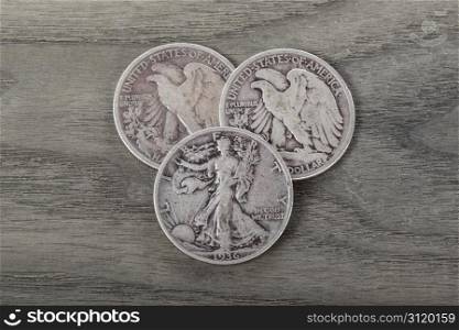 Old silver half dollars on aging wood background