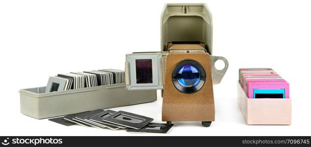 Old slide projector and set of slides isolated on white background. Retro equipment. Wide photo.