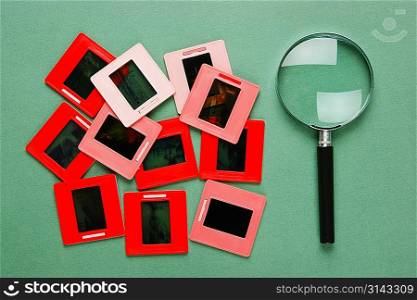 old slides and a magnifying glass on green table