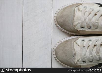 Old sneakers on white wooden floor background.. Old sneakers on white wooden floor background and have copy space for design in your work.