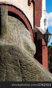 Old St. John Baptist church and stone monk figure near (Lviv, Ukraine)