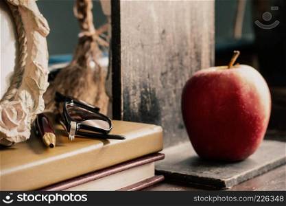 Old stationery and apple on the desk.