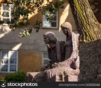 Old statue of couple on the wall of Old Town in Warsaw