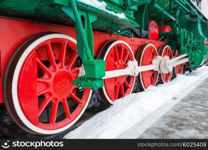 Old steam locomotive wheels on railway track closeup