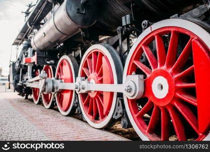 Old steam train, red wheels closeup. Vintage locomotive. Railway engine, ancient railroad vehicle