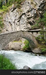 old stone bridge and home over Verney Dora in Pre Saint Didier, Aosta Valley, Italy