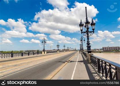 Old stone bridge in Bordeaux in a beautiful summer day, France