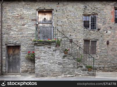 Old stone building facade with outside steps in the village of Clun, Shropshire, England.