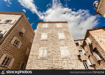 Old stone building with closed windows at sunny day