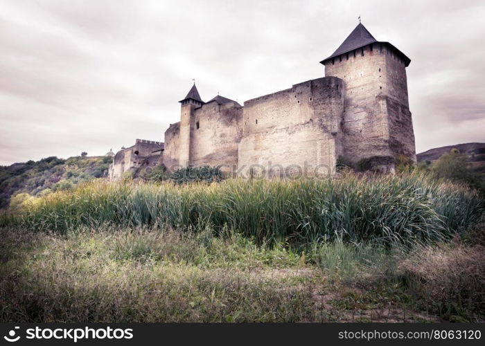 Old stone castle on background of cloudy sky. Old stone castle